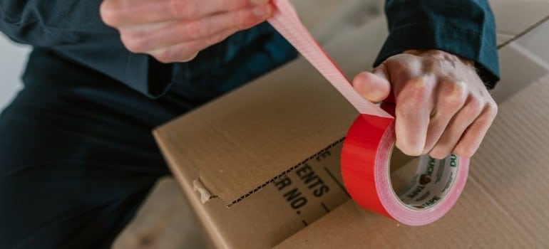 person taping a box