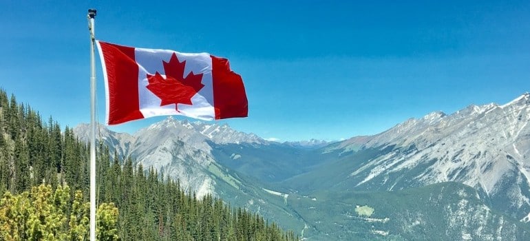 Canadian flag on top of the mountains