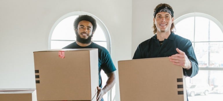 Two movers holding moving boxes while moving from Kitchener to Hamilton