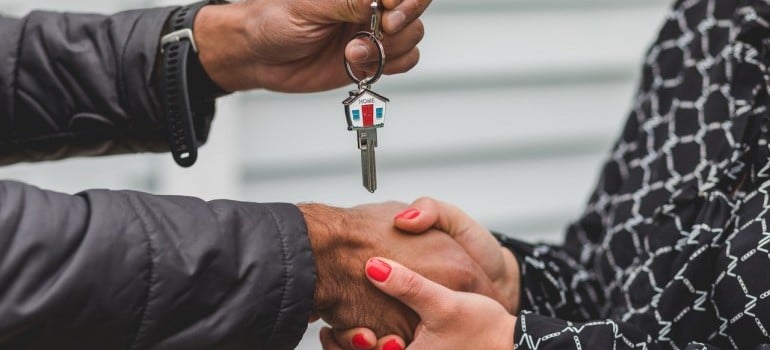 A person giving keys to a hoem to another person