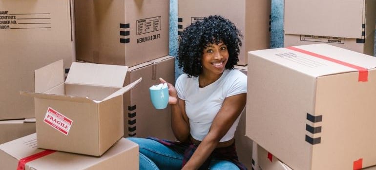 woman sitting near cardboard boxes