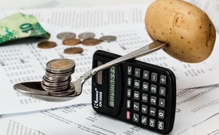 calculator balancing a fork, representing budgeting