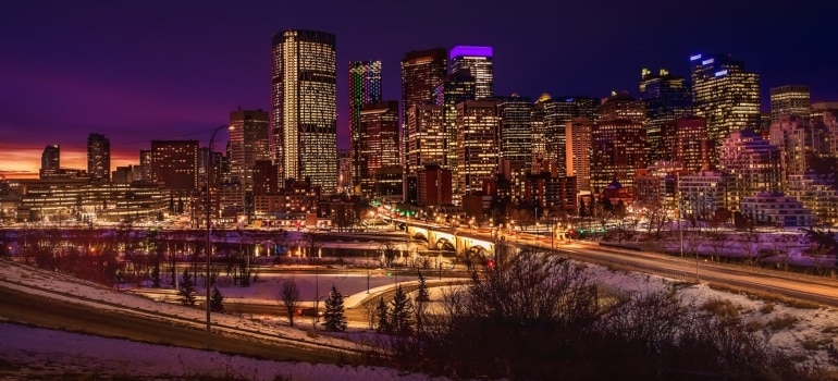 a lit up city area in dawn to show the beauty of the city and explain what makes Calgary a perfect place for living