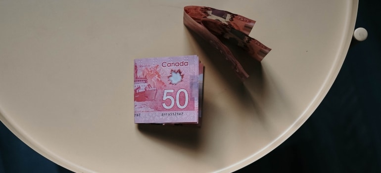 Canadian dollars sitting on a white table to depict the cost of living when relocating to Newfoundland