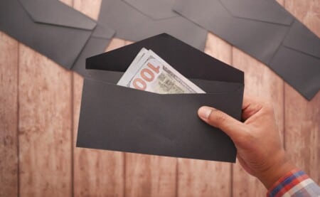 person holding envelope with money