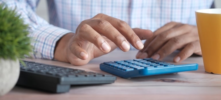 a man using a calculator to calculate the costs of the move