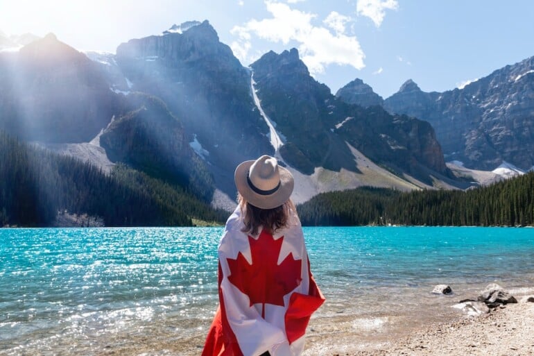 person holding a canadian flag and thinking about similarities and differences between Ontario and Quebec