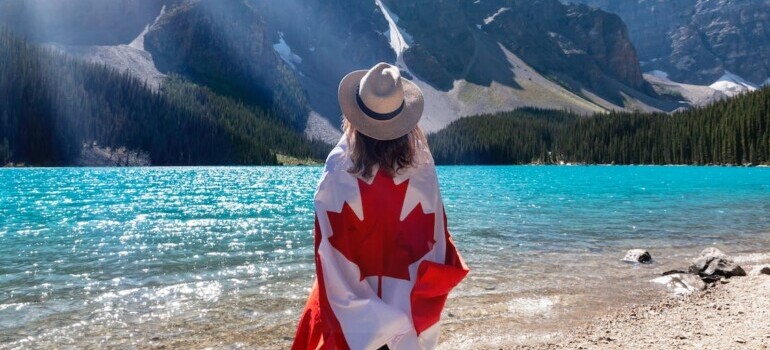A woman with a Canadian flag overlooking the lake