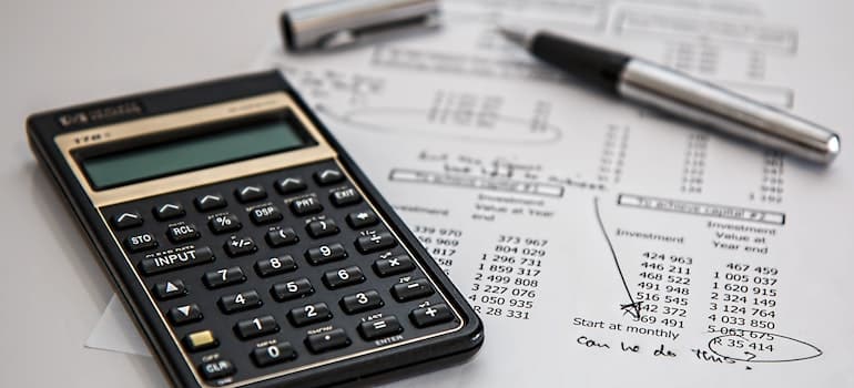 A calculator and paper are required for budgeting before hiring moving companies Medicine Hat.