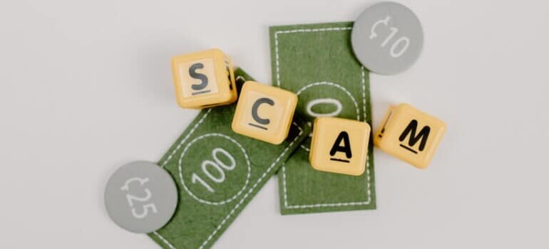 Fake money and a scrabble word scam written on the blank space