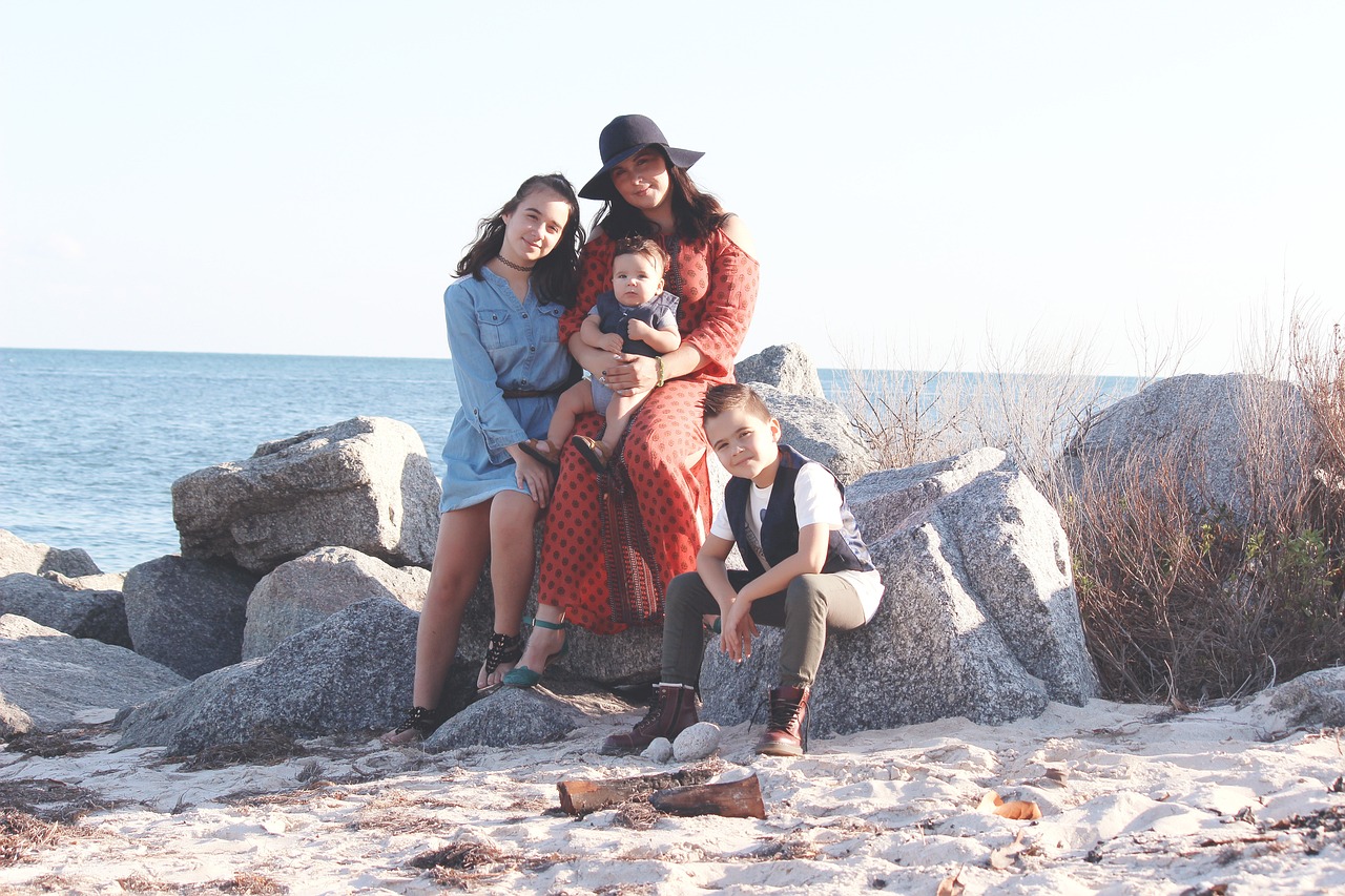mother and three kids posing at the beach