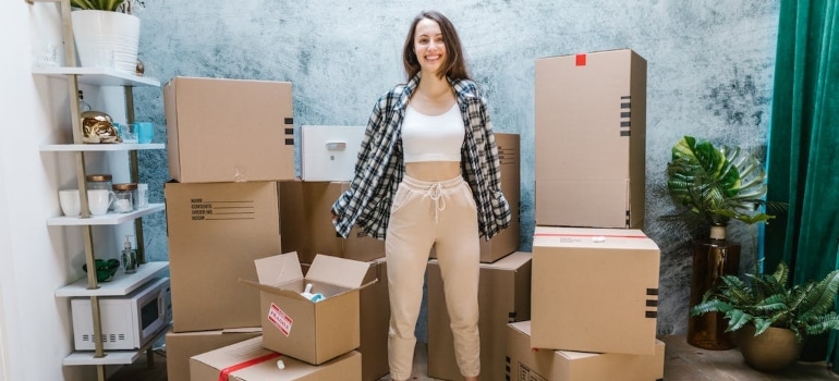 a woman with lots of boxes behind her