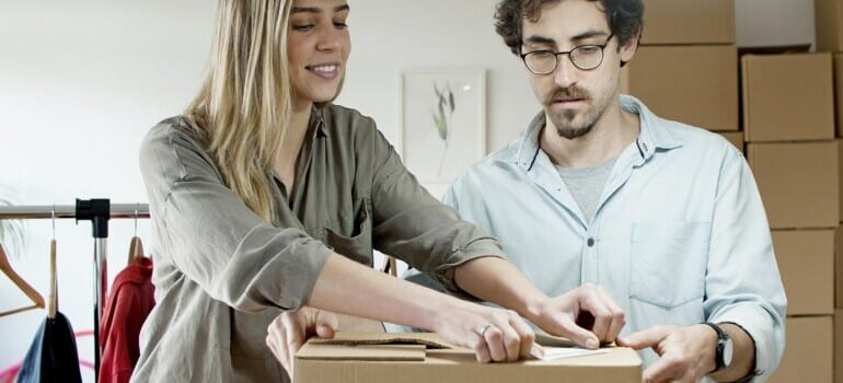 Man and woman packing closing and taping a box