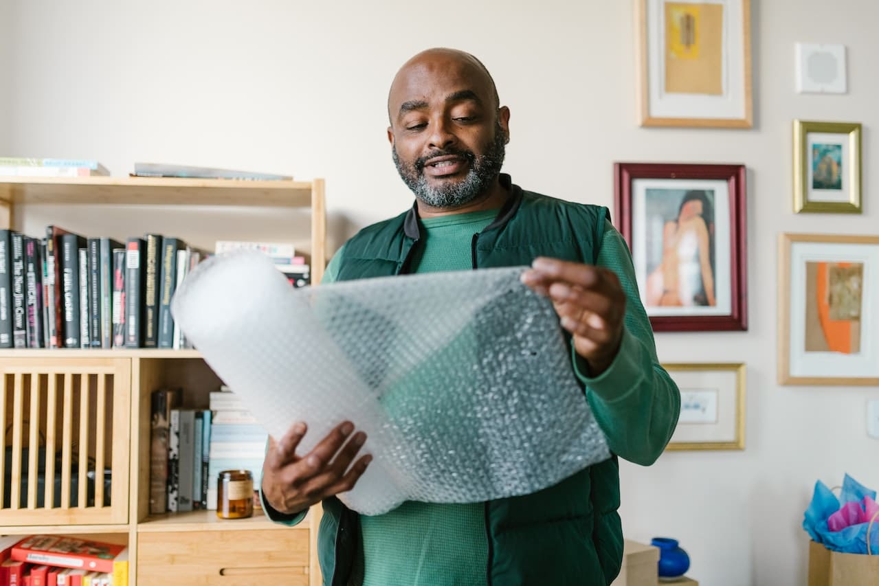 a man holding a roll of bubble wrap