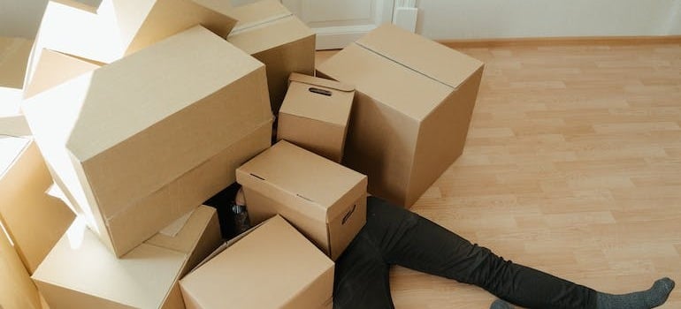 A person under a lot of moving boxes