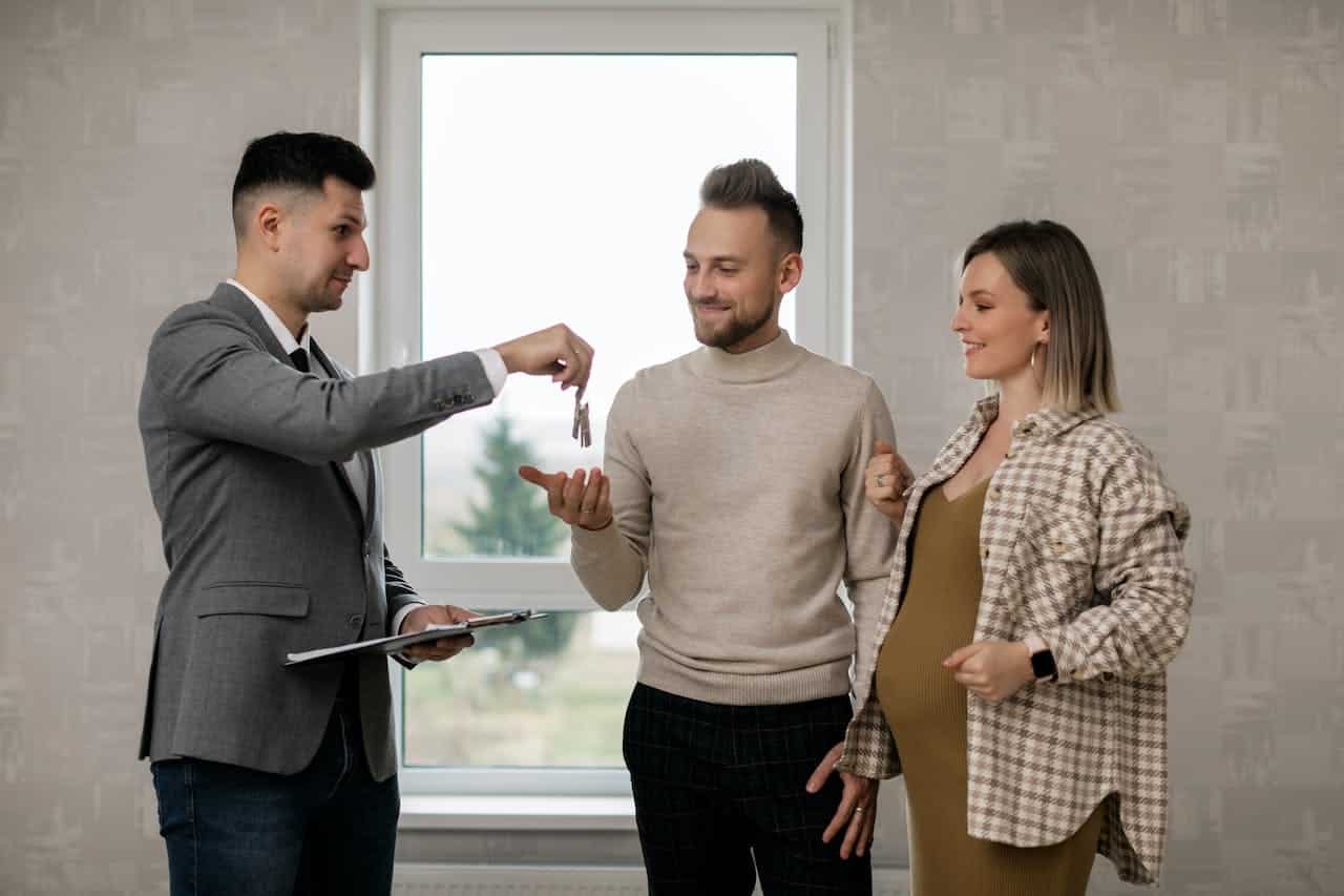 real estate agent handing over the keys to a couple