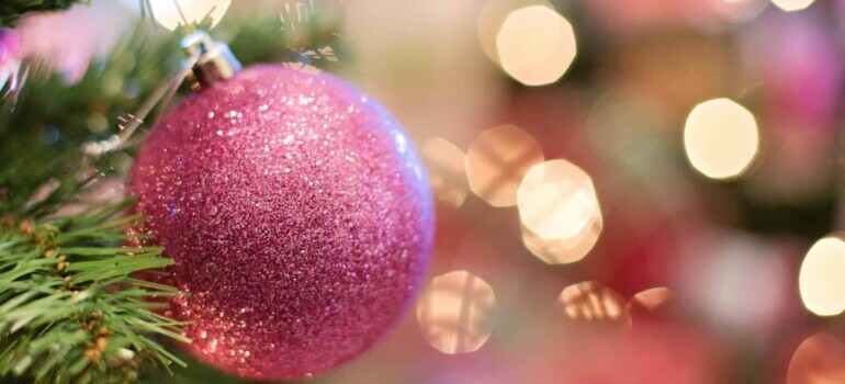 pink Christmas ball and lights behind it