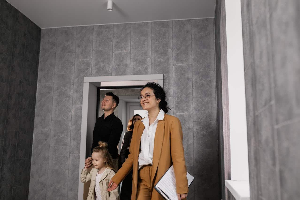 A family and a real estate agent walking into a house