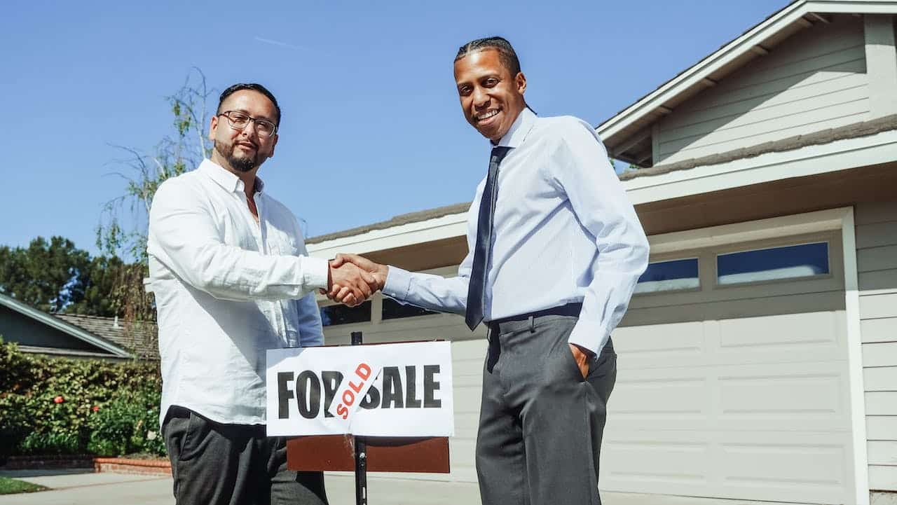 a man shaking hands with a real estate agent