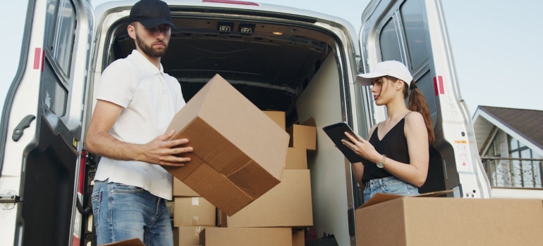 two people unloading moving van