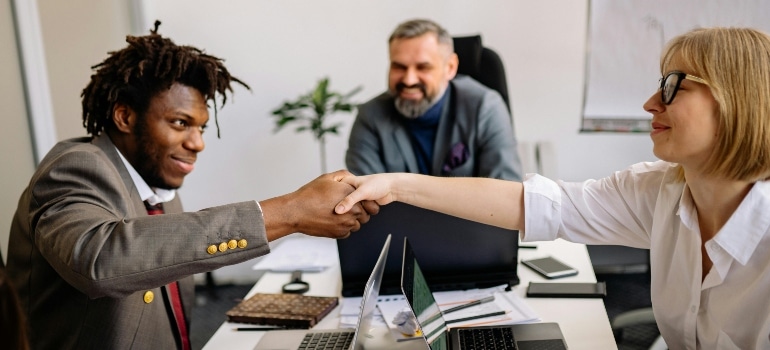 Colleagues celebrating a successful introduction with a handshake — Starting a New Job in Montreal After Moving From Kingston.