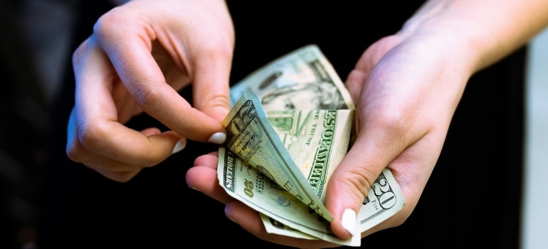 Person counting money before moving to one of the budget-friendly cities in Quebec