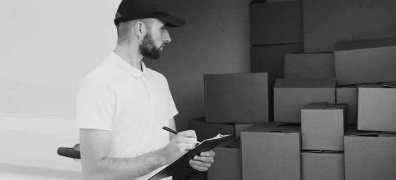 Person looking at boxes in a van before moving from Alberta to Ontario