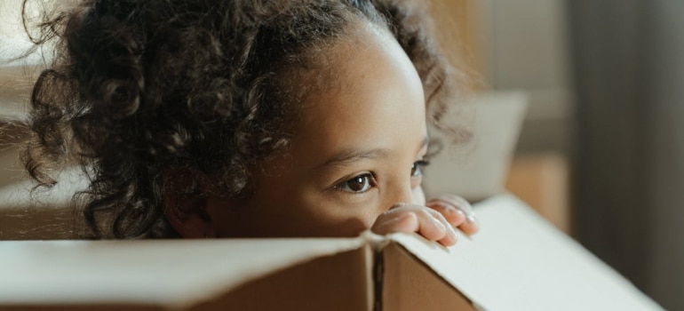 Child playing in a box before moving from Toronto to Montreal