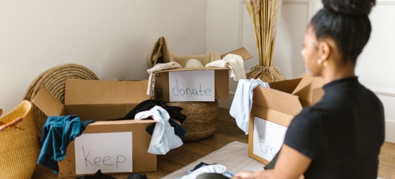 Person looking at labeled boxes and thinking about the moving tips Canada locals reccomended to her