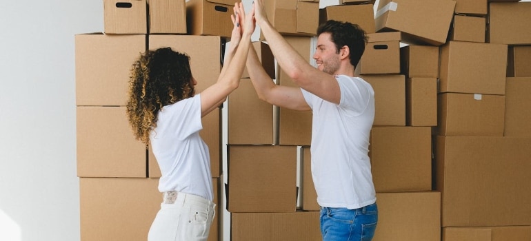 Couple celebrating in front of moving boxes
