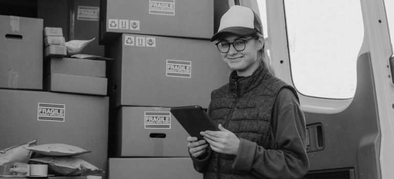 Person standing next to stacked boxes before moving from Ontario to Quebec