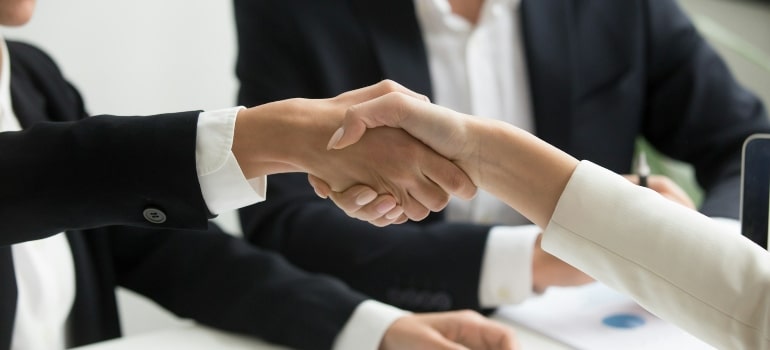 People shaking hands after talking about the pros and cons of moving to Ottawa from Toronto