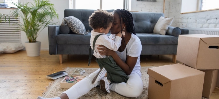 Mother and child sitting among moving boxes getting ready for long distance moving